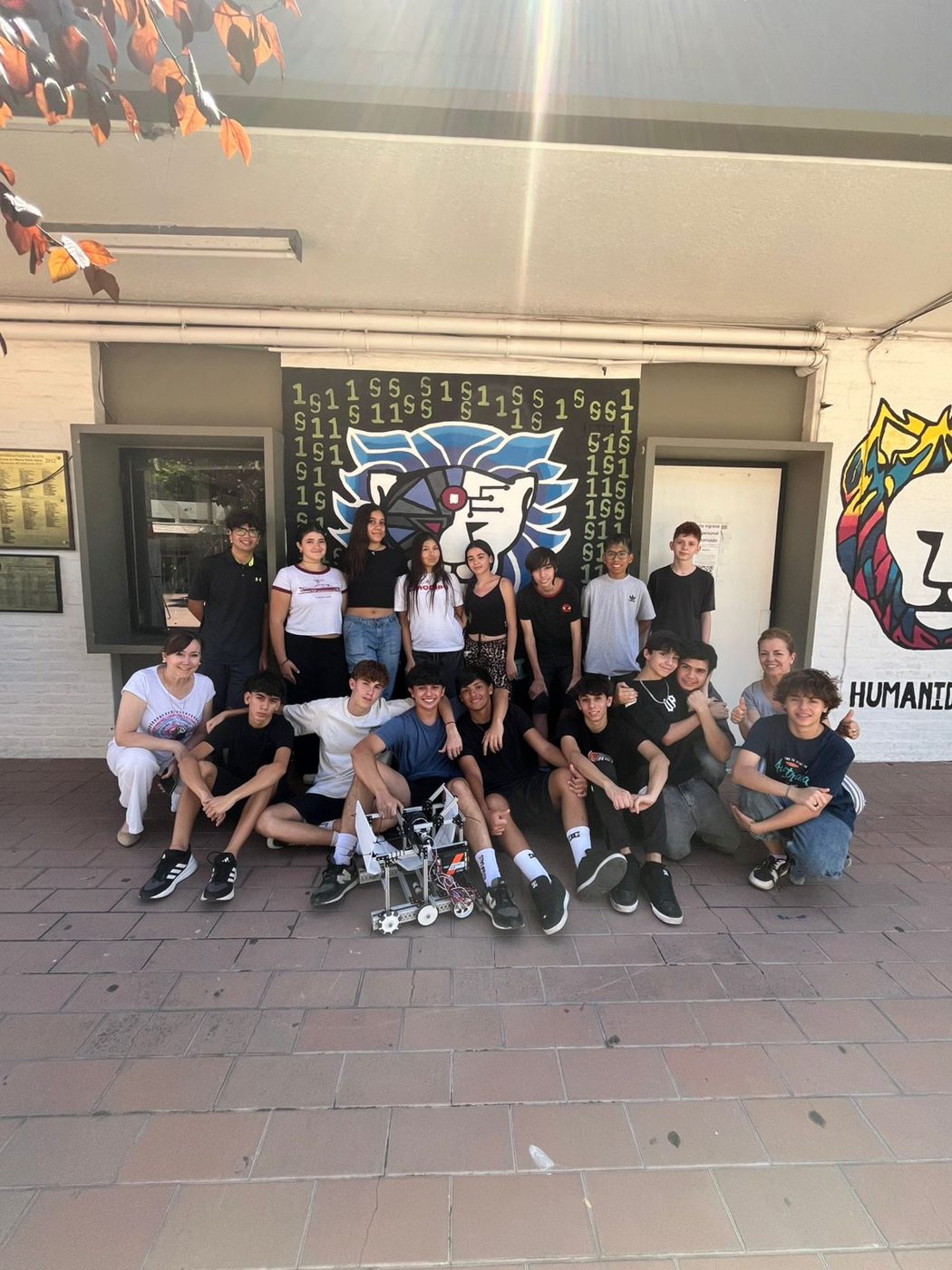 El equipo frente al mural del león